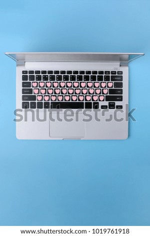 Laptop with hearts keyboard on light blue pastel colored backdrop; Flat lay; Valentine's Day and Love background or greeting card template, space for text, Vertical
