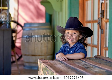 Toddler boy wearing a cowboy outfit poses for a portrait in Tucson, AZ.