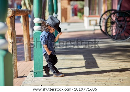 Toddler boy wearing a cowboy outfit poses for a portrait in Tucson, AZ. Royalty-Free Stock Photo #1019791606