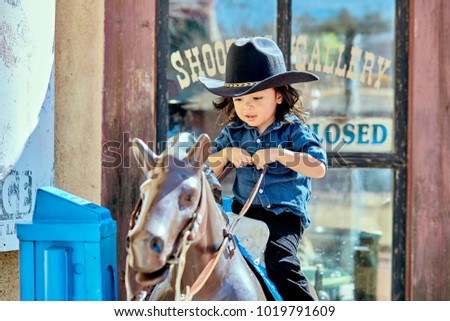 Toddler boy riding a mechanical toy horse in Tucson, AZ.