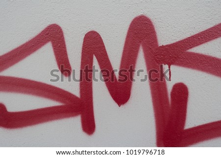 red graffiti letters on a grey wall