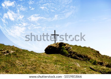 catholic cross in the mountains with planet Earth