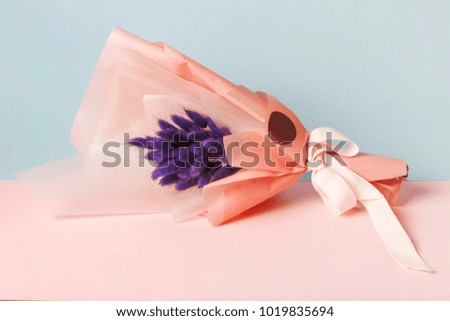 purple bunny (rabbit) tail grass in bouquet on light blue background