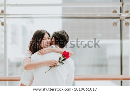 Happy beautiful young Asian woman embracing her boyfriend after receive a rose on valentine day. Royalty-Free Stock Photo #1019861017