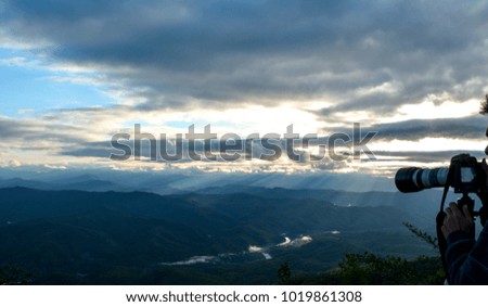Asian men photographing mountain and morning sun in Thailand