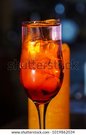 red cocktail in a tall glass on the bar. close-up