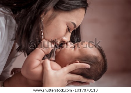 Portrait beautiful mother kiss her baby child. Mom nursing baby. mom and baby boy relax at home. Nursery interior. Mother breast feeding baby. Family at home. Mom's love. selected focus, vintage style Royalty-Free Stock Photo #1019870113