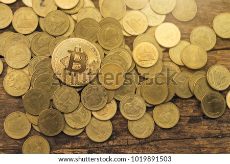 Golden Bitcoin Cryptocurrency and coin on wooden table.