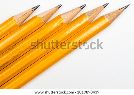 Multiple sharpened pencils against a white background