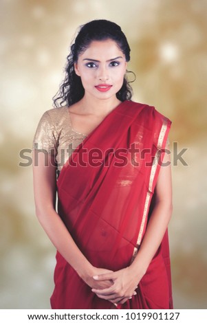 Confident Indian woman posing over blurred background