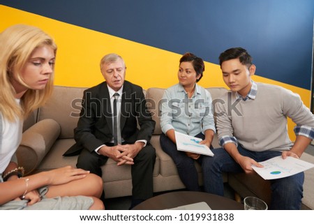 Coworkers listening to senior entrepreneur at the meeting