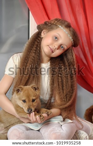Girl sitting with a puppy in her arms