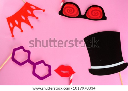 Purim , mardi gras, april fools day holiday greeting card. Cute carnival masks on stick: paper glasses, lips, crown on pink background.Copy space for text. Top view.Flat lay.