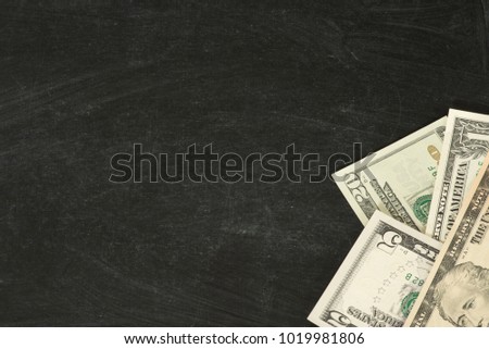 Dollar bills on a black chalkboard