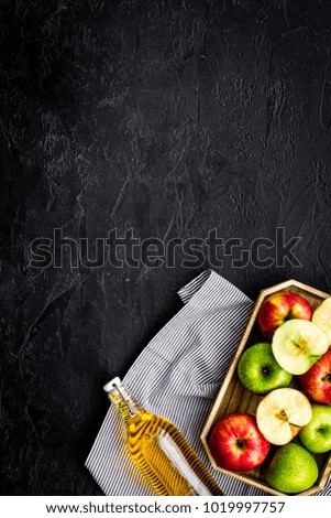 Bottle of fresh cider near autumn apples. Black background top view space for text