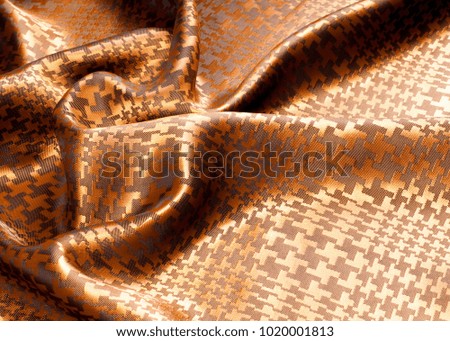The texture of the silk fabric, painted with a brown pattern.  macro texture of brown striped fabric studio. Artistic fabric texture, folded, wavy. 