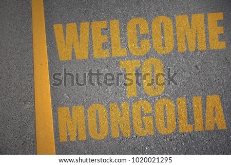 asphalt road with text welcome to mongolia near yellow line. concept