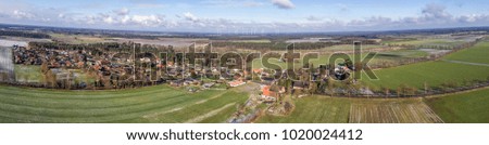 Aerial landscape photo, panoramic view of a small village between fields and meadows, as banner for a blog or website, drone shot
