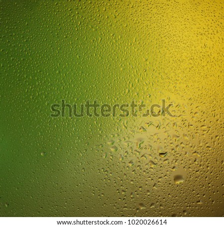 Natural water drops on glass green colors