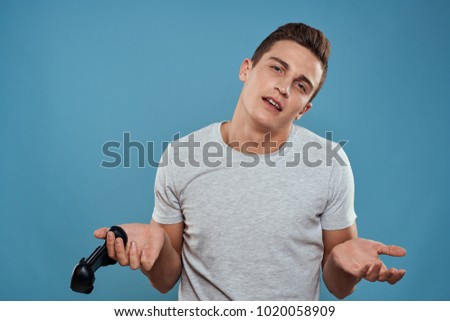  man with joystick looking at camera on blue background                              
