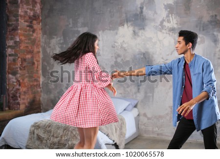 Attractive African-American couple dancing at home