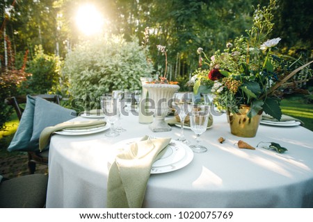 family dinner in the backyard of the house, round table, beautiful decor Royalty-Free Stock Photo #1020075769