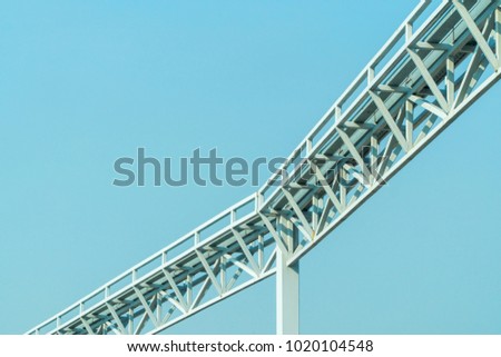 Long white steel frame with blue sky.
