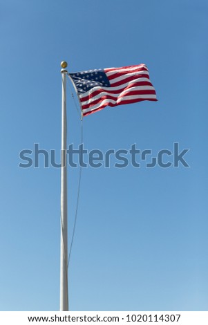 United states flag flowing with a wind on a blue sky background