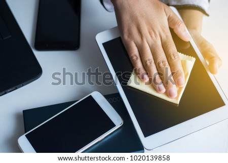 Hand woman cleaning tablets dirty on screen with microfiber cloth,Ipad