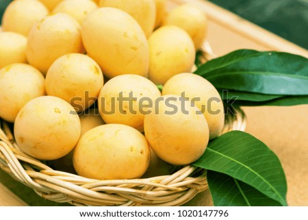 Plum Mango decorated in the basket on wooden background.