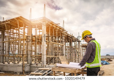 young business man professional engineer worker at the house building construction site with blueprint Royalty-Free Stock Photo #1020149479