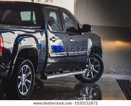 Black colored pick up truck after body wash in the Garage-side view Royalty-Free Stock Photo #1020152872