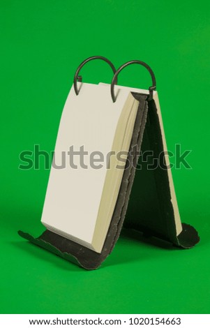 Flipchart for notes, calendar on a metal forged base on a green background
