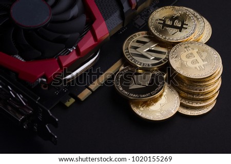 cryptocurrency mining concept with golden bitcoin  litecoin and Ethereum golden coins next to a computer performant video card black background Royalty-Free Stock Photo #1020155269