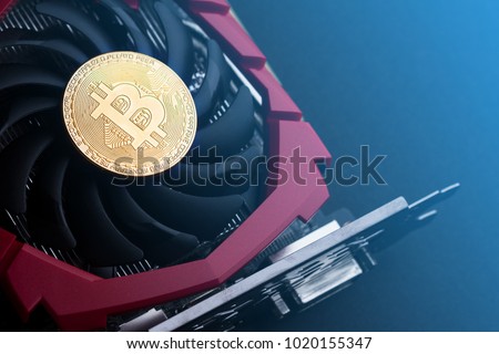 cryptocurrency mining concept with one golden bitcoin on top of a computer performant video card black fan Royalty-Free Stock Photo #1020155347