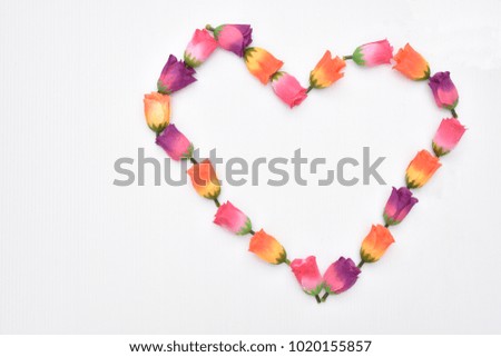 Orange rose Purple Roses Pink roses arranged in a heart-shaped pattern on white background.