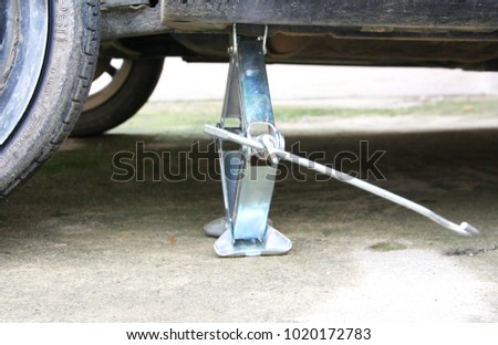 Photo for dirty car with tire break down and scissor car jack.