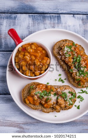 Open sandwich with beans and vegetables in tomato sauce. Selective focus.