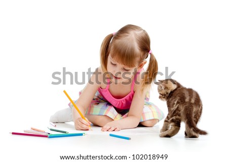 Cute girl drawing a picture with color pencils. Kitten looking at child.