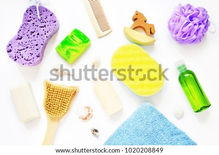 Flat lay bath accessories, herbal organic cosmetic products. Purple sponge, green handmade soap bar, essential oil, shampoo bottle, seashells and brushes for dry anti-cellulite massage and treatment