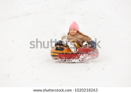 Photo of girl riding tubing in winter park