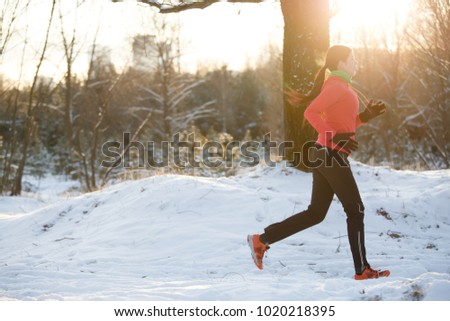 Picture of sports girl on run through winter forest