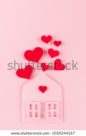 Valentines day background of pink paper house and stream soar small red  hearts on pink paper background.