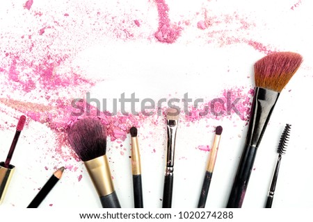 Traces of vibrant pink powder and blush forming a frame, with makeup brushes and lip gloss. A template for a makeup artist's business card or flyer design, with a place for text