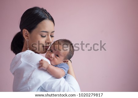 Portrait young mother holding her newborn child. Mom nursing baby. mom and baby boy relax at home. Nursery interior. Mother breast feeding baby. Family at home. Mom's love. Royalty-Free Stock Photo #1020279817