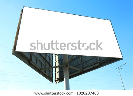 Blank advertising board outdoors against blue sky