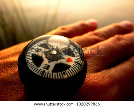 compass on hand showing the North direction with small heart on it as to say let love lead the way