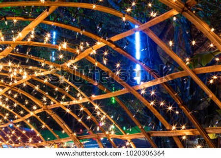 Little orange lights, hanging from the ornate decor, beautifully decorated with a bamboo frame at night.