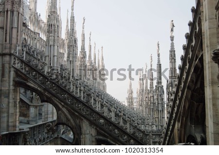 View of architectural detail of Duomo di Milano roofs. Foogy morning. Gloomy gothic Royalty-Free Stock Photo #1020313354
