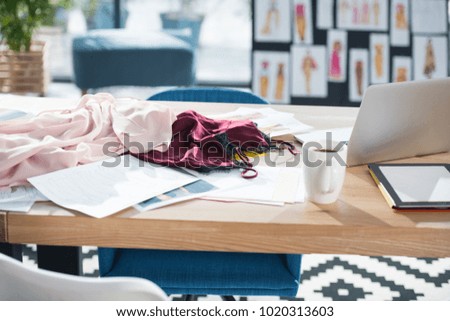 messy fashion designer workplace at modern office